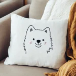 A cute puppy embroidered on a white cushion, placed on the sofa as a decoration.