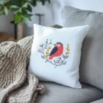 A knitted blanket and a white bird embroidery pillow on the sofa