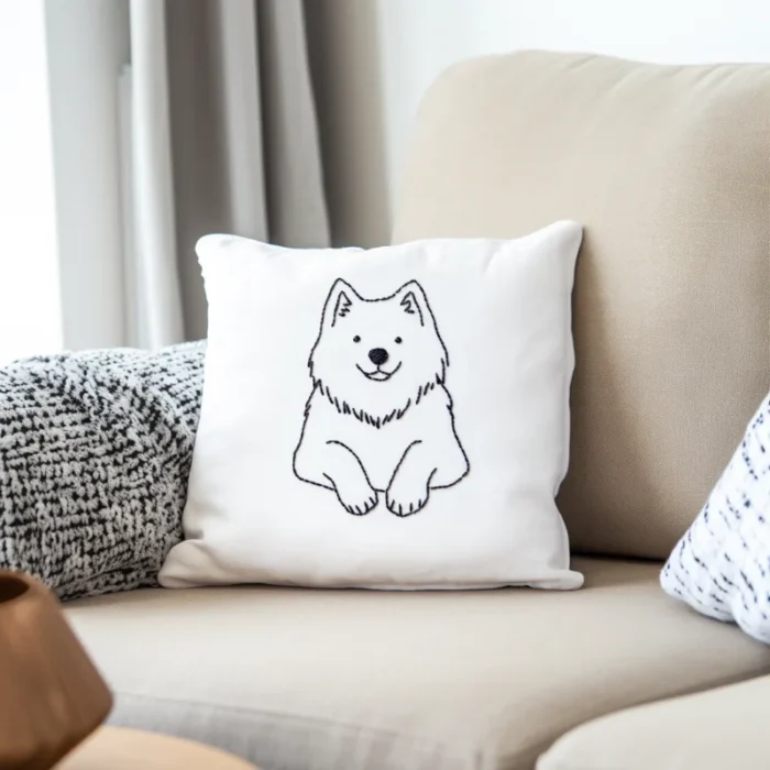 An embroidered design of a smiling dog lying down, stitched on a sofa cushion.