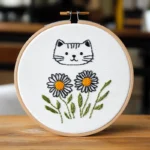 Close-up Cozy Kitten and Daisy Hand Embroidery Artwork