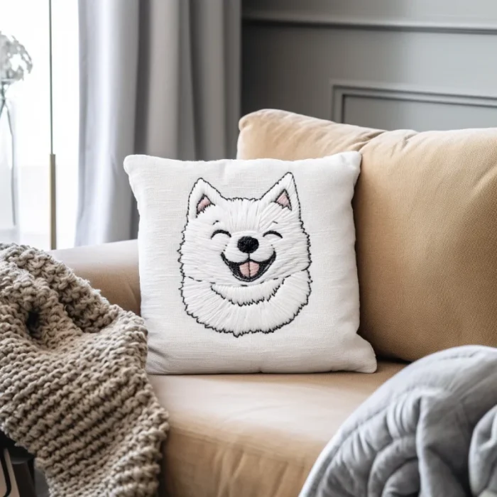 A smiling Samoyed embroidery pattern stitched on a pillowcase, placed on a sofa.