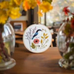A table decorated with vases of fresh flowers on both sides and an embroidery piece in the center