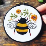 Close-up of a chubby bee and colorful flowers embroidery artwork