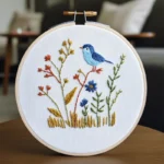 Close-up of a handmade blue bird embroidery artwork