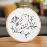 Close-up of a minimalist line art bird embroidery artwork