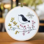 Close-up of an autumn-themed bird embroidery artwork