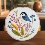 Close-up shot of vivid blue bird and vibrant multicolored branch embroidery artwork