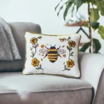 Rectangular throw pillow featuring bee and flower embroidery