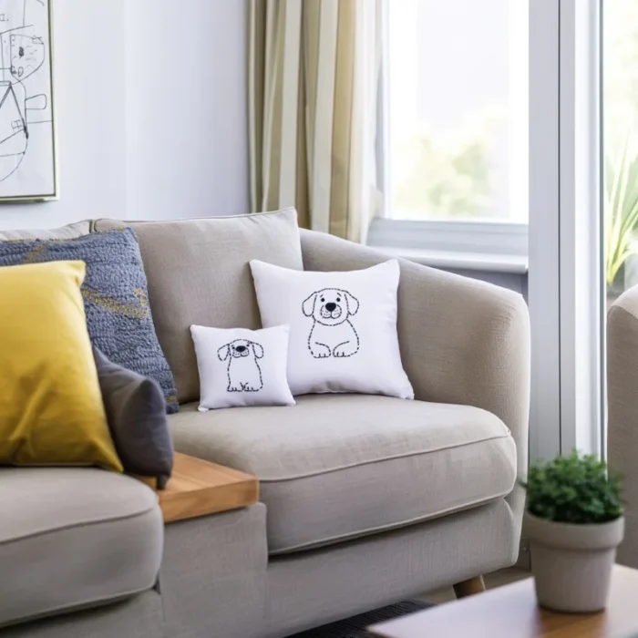 Sofa decorated with multiple throw pillows, featuring two eye-catching dog embroidery pillows with simple line art