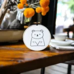 Adorable bear embroidery piece displayed on a tabletop