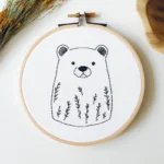 Close-up of a brown bear and wild grass embroidery design