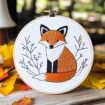 Close-up of a fox embroidery artwork placed on a wooden board