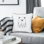 Gray sofa with a brown bear embroidery pillow and an orange cushion