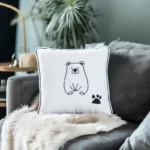 Minimalist line bear embroidery pillow placed on a fluffy blanket