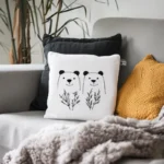 Gray sofa with a black pillow, a knitted cushion, a white bear embroidery pillow, and a gray plush blanket