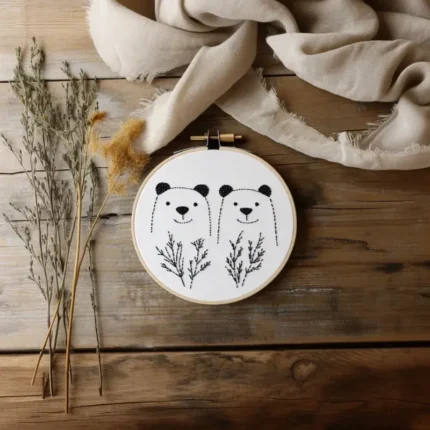 Hand embroidery artwork with decorative dry branches and white fabric on a table