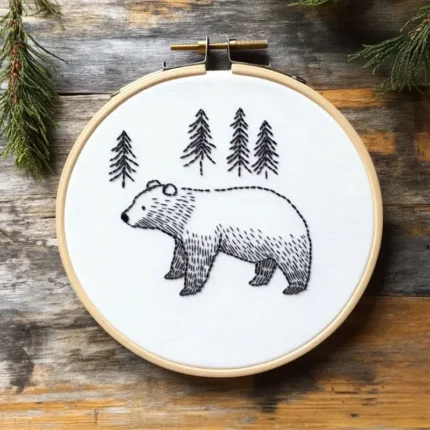 Detailed handmade bear embroidery artwork featuring a bear walking through a forest