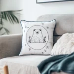 Bright living room with a gray sofa and a white pillow embroidered with a peaceful little bear