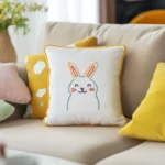Warm beige sofa with multiple colorful pillows, including one embroidered with a cute rabbit