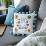 Blue and white cushions with rabbit and wildflower embroidery on sofa