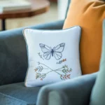 blue armchair with delicate handmade butterfly embroidery cushion