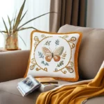 brown sofa with embroidered cushion, book, and cozy blanket