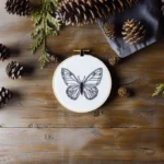 handmade black butterfly embroidery on table with pinecones as decoration
