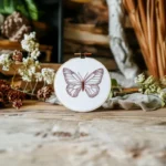 handmade butterfly embroidery on table with fresh flowers as decoration