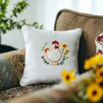 cozy-sofa-with-a-handmade-cushion-embroidered-with-a-chicken-and-daisies
