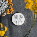 dandelion embroidery in the center, decorated with yellow and white flowers around it