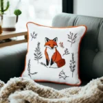 dark gray sofa with a blanket and a decorative fox embroidery cushion