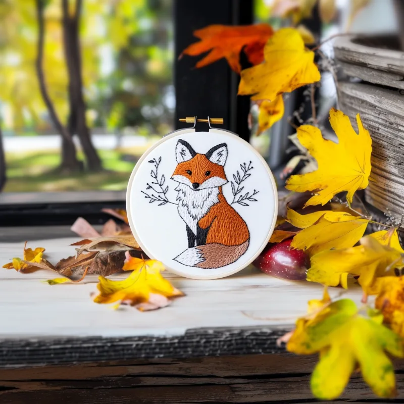 fox embroidery artwork on the floor, decorated with autumn leaves fox embroidery artwork on the floor, decorated with autumn leaves