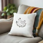 gray sofa with a blanket and a white cushion embroidered with a chicken