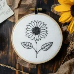 hand embroidery artwork of a sunflower stitched with black and white threads