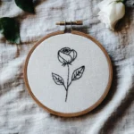 hand embroidery of a rose stitched with black thread