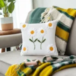 handmade daisy embroidery cushion placed on a blanket on the sofa