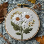handmade embroidery of two daisy flowers placed on a table