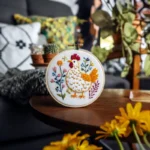 handmade embroidery on a wooden round table, accompanied by yellow flowers