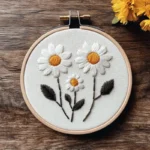 minimalist daisy embroidery featuring three daisies nestled together like a family