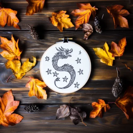 oriental dragon embroidery design on a wooden table with scattered autumn leaves
