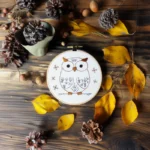 owl hand embroidery placed on the floor with fallen leaves as decoration