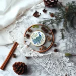 peacock-themed embroidery design on a table with lace fabric and branches as decoration