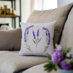 sofa with an embroidery cushion and a bouquet of flowers next to it