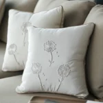 sofa with multiple cushions, some embroidered with delicate dandelion patterns