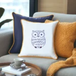 three pillows on a sofa in orange, dark blue, and white