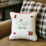 two cushions on a sofa, one with a striped checkered pattern and the other with a hand-embroidered design