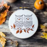 two owls perched on a branch, quietly gazing, hand embroidery artwork display