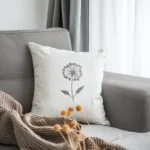 Sofa with a cozy cushion and a blanket placed neatly on top