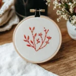 a completed hand-embroidered piece featuring red wildflowers