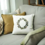 a solid-color pillow and a floral wreath embroidered pillow on the sofa